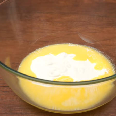В другую миску наливаем 150 г растопленного сливочного масла, ¾ стакана сметаны, сметану можно заменить кефиром и 100 г сахара. 