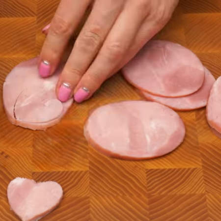 Из колбасы вырезаем сердечки формочкой, которая поменьше.