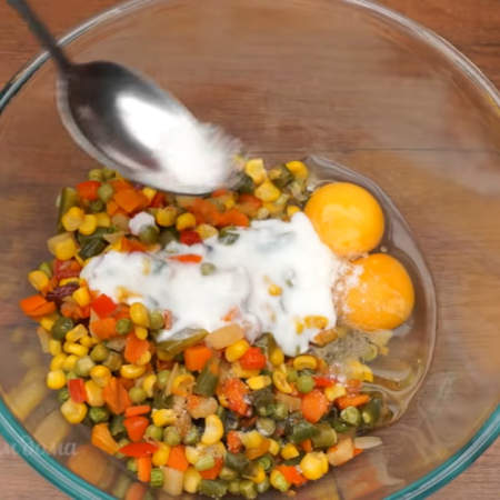 Подготовленные остывшие овощи кладем в миску. К ним разбиваем 2 яйца. Наливаем 2 ст. л. кефира или сметаны. Все солим по вкусу и перчим.
Перемешиваем ложкой до однородности.