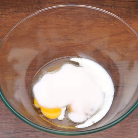 Сначала замесим тесто.
В миску разбиваем 2 яйца, наливаем 2 ст. л. молока и насыпаем 130 г сахара.