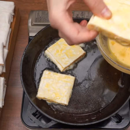 Каждый кусочек лаваша обмакиваем со всех сторон во взбитых яйцах и выкладываем на разогретую сковороду с небольшим количеством растительного масла. 
