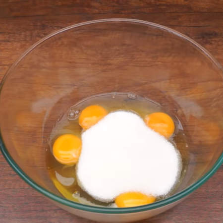 В миску разбиваем 4 яйца и насыпаем 200 г сахара. 