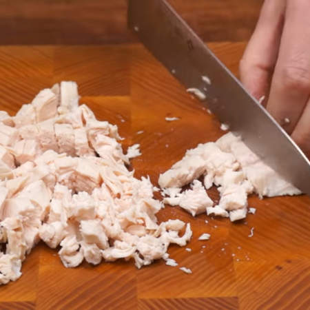 Сначала подготовим начинку.
200 г отварного куриного филе нарезаем кубиками. Куриное филе можно заменить любым мясом или колбасой.