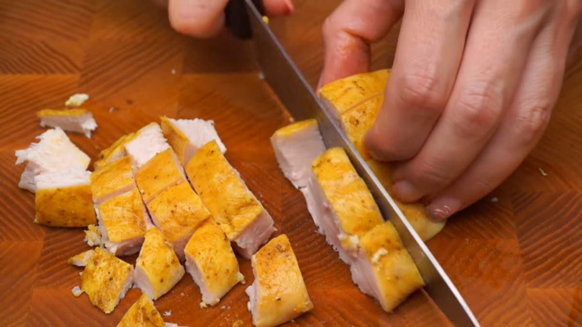 300 г запеченного куриного филе нарезаем кубиками. 
Также в салате можно использовать отварное или жареное куриное филе.