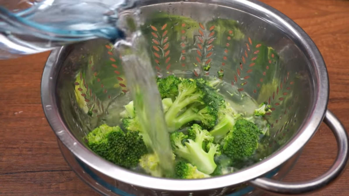 Спустя 4 минуты с брокколи сливаем горячую воду и сразу же обдаем капусту холодной водой. Это делается для того, чтобы брокколи осталась красивого зеленого цвета.

