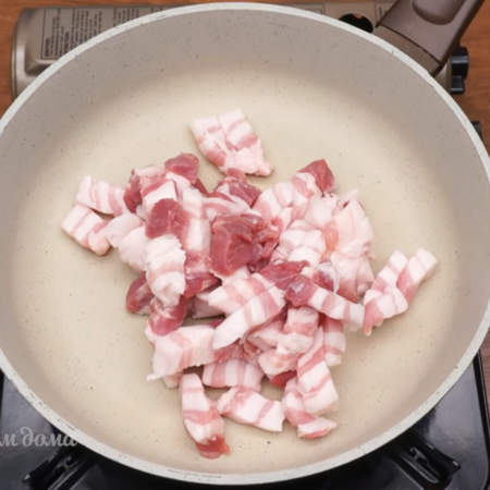 На сухую горячую сковороду кладем нарезанную свиную грудинку 