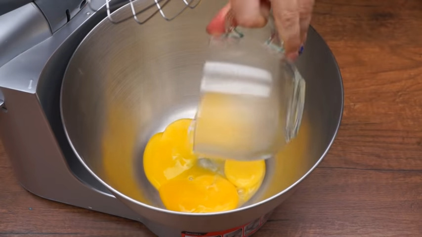 Сначала приготовим тесто для коржей.
4 желтка выливаем в миску. К ним наливаем 4 ст.л. кипятка и сразу же начинаем взбивать.