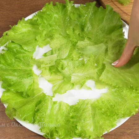 Складываем салат.
На плоское блюдо выкладываем листья салата.  Отрываем руками крупные кончики листьев и кладем их по краю блюда. Мелкие части выкладываем в средину.