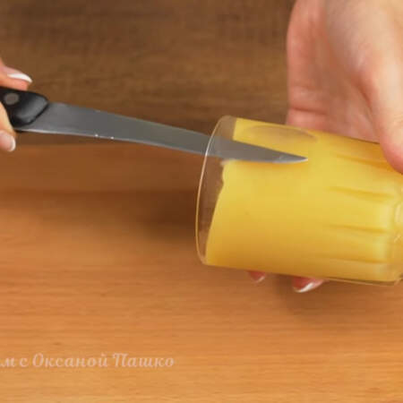 Держим стакан боком и вставляем узкий нож между стенкой стакана и десертом.