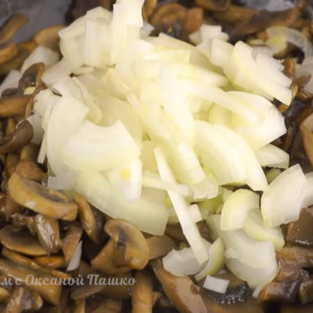 Когда из грибов испарится вся жидкость, добавляем немного подсолнечного масла и нарезанный лук. 
Жарим на среднем огне до готовности лука