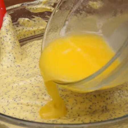 Сюда же в тесто, в несколько подходов, добавляем 100 г растопленного сливочного масла.