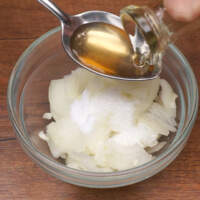 Подготовленный лук кладем в небольшую мисочку. К нему насыпаем 0,5 ч.л. соли, 1 ч.л. сахара и наливаем 2 ст. л. уксуса. Я использую яблочный, но можно взять и столовый 9%.