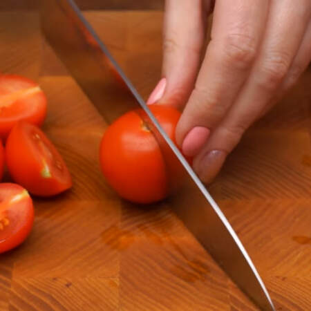 250 г помидоров черри разрезаем на половинки.