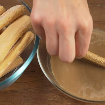 Складываем торт.
Печенье Савоярди обмакиваем в приготовленном кофе и сразу же выкладываем в форму. 