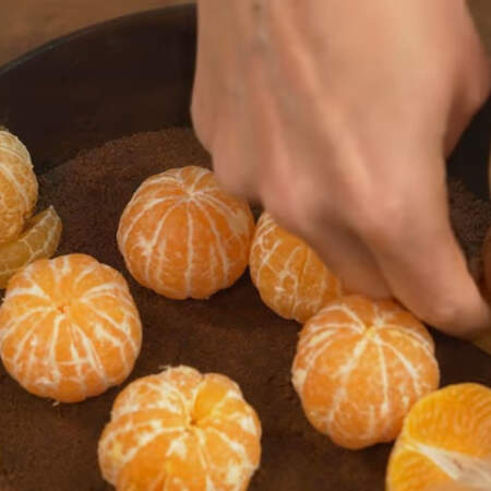 Для того, чтобы половинки мандаринов прижать к ботику, подставляем под них по одной дольке.