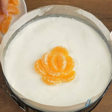 Сливочно-йогуртовый слой уже застыл. Выкладываем на него мандариновые дольки по кругу.