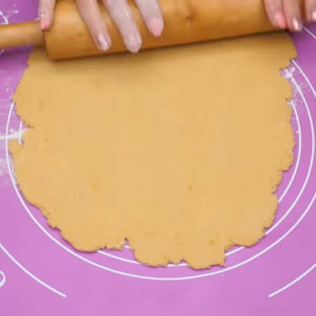 Охлажденное тесто совсем немного разминаем руками и раскатываем в пласт.
Коврик и тесто немного посыпаем мукой.