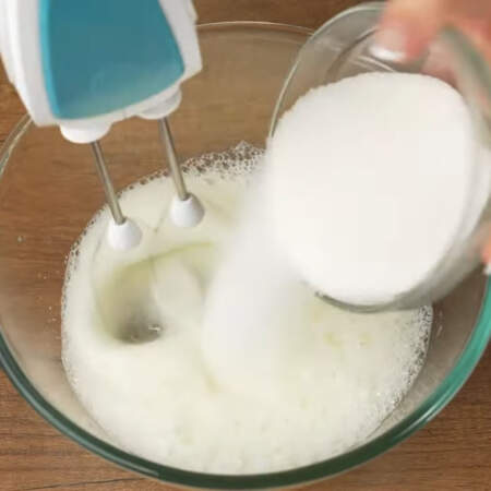 В белки добавляем щепотку соли и начинаем взбивать. Когда появится пена постепенно добавляем 80 г сахара. 