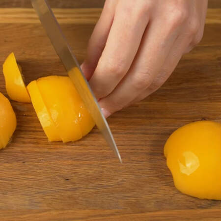 4-5 половинок консервированных персиков нарезаем пластинками. Сок от персиков тоже пригодится для пропитки бисквита.