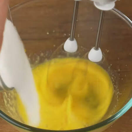 В отдельную миску разбиваем 1 яйцо. Начинаем его взбивать и постепенно насыпаем оставшийся сахар.