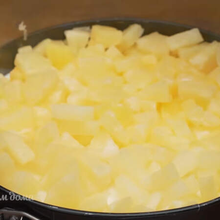 Йогурт застыл, выкладываем на него две банки консервированного ананаса нарезанного кусочками и равномерно распределяем его по всей поверхности.