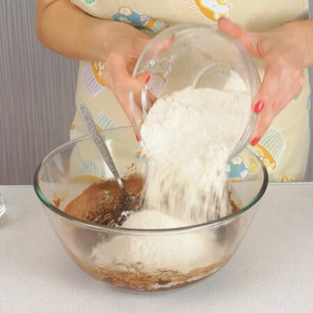 В тесто добавляем половину муки и насыпаем 1 ч.л. разрыхлителя. Сначала перемешиваем ложкой, а затем руками. 