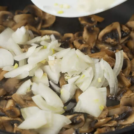 Как только вся жидкость из грибов испарилась, наливаем немного растительного масла. Сюда же кладем нарезанный лук. 