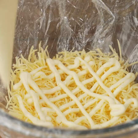 Первым слоем кладем тертый сыр. Примерно 20 г сыра оставляем, он нам понадобится немного позже.
Наносим сеточку из майонеза. 
