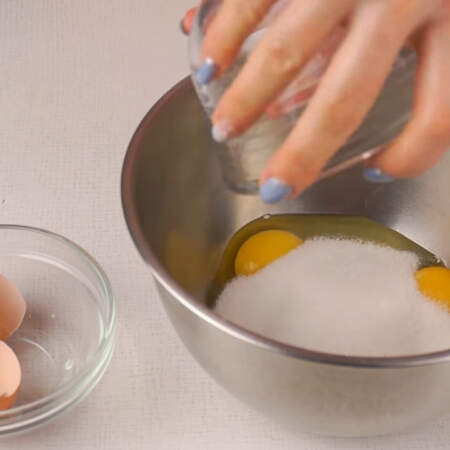 В миску разбиваем 2 яйца и высыпаем к ним сахар. 