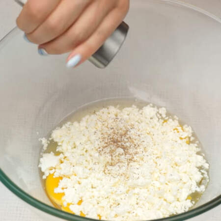 В отдельную миску разбиваем 2 яйца, добавляем 150 г творога, перчим по вкусу.