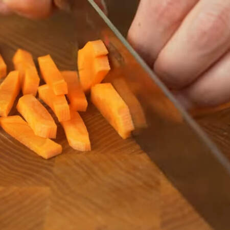 2 морковки разрезаем сначала вдоль на пластинки, а затем пластинки нарезаем брусочками.