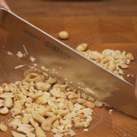 70 г жареного арахиса измельчаем ножом на более мелкие кусочки.