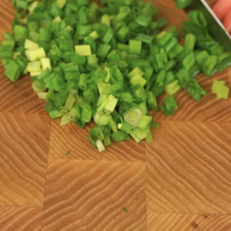 Небольшой пучок зеленого лука тоже мелко нарезаем ножом.
Всю зелень смешиваем вместе.