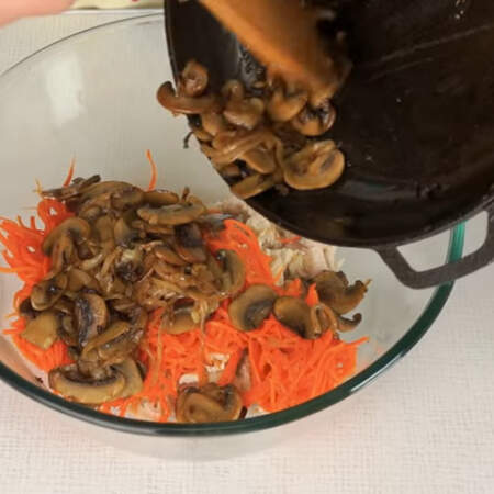 В миску кладем нарезанное мясо, 200 г морковки по корейски и обжаренные грибы с луком.