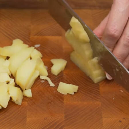 Сначала подготовим все ингредиенты для салата.
2 вареные картофелины нарезаем сначала пластинками, а затем небольшими кубиками.