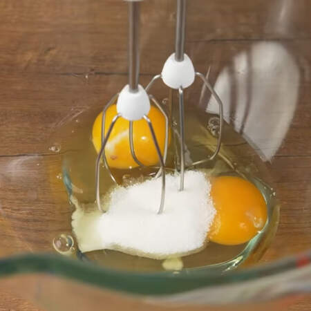 Сначала приготовим блины.
В миску разбиваем 2 яйца. Насыпаем 0,3 ч. л. соли и 1 ст. л. сахара. 