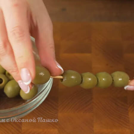 Зеленые оливки нанизываем на шпажку.