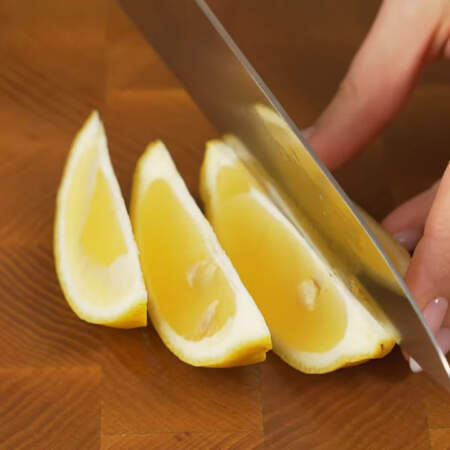 Лимон разрезаем пополам и нарезаем дольками.
Точно также отрезаем дольку от лайма.