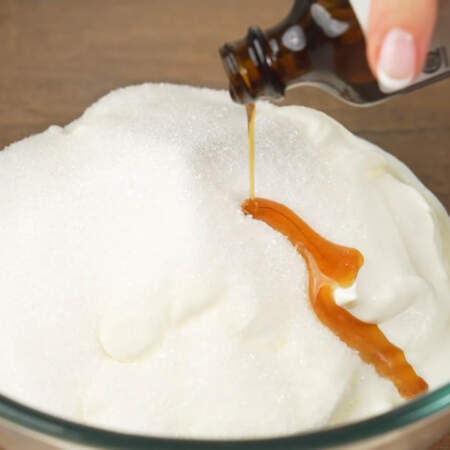 В миску наливаем 800 г сметаны, насыпаем 150 г сахара и добавляем примерно 1 ст. л. ванильного экстракта или 10 г ванильного сахара.