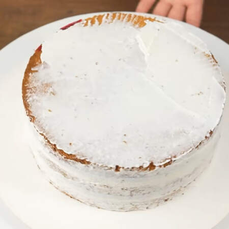 Торт по бокам и сверху украшаем оставшимся сметанным кремом. Сначала наносим тонкий черновой слой крема, чтобы прибить крошки. 