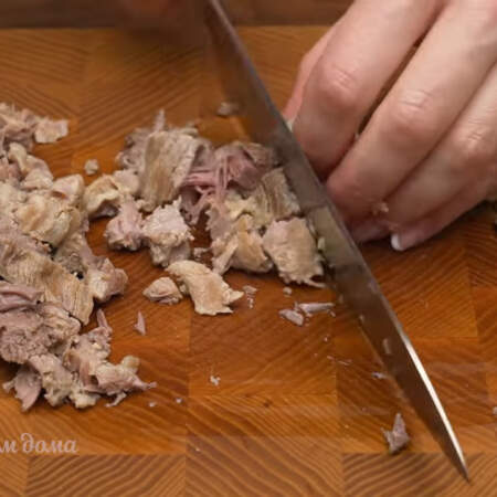 С уже немного остывшего мяса вынимаем косточки. Мясо нарезаем небольшими кусочками.