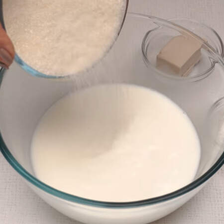 Сначала приготовим опару. В миску вливаем теплое молоко, насыпаем примерно 100 г сахара, пол чайной ложки соли