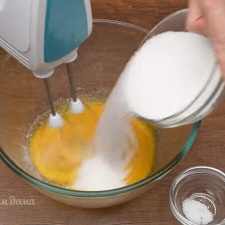 Желтки  начинаем взбивать и постепенно добавляем оставшиеся 230 г сахара. Сюда же добавляем и 20 г ванильного сахара и щепотку соли.