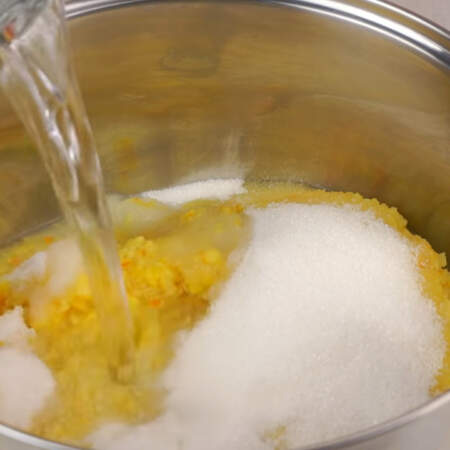 Измельченные апельсины и лимоны перекладываем в большую кастрюлю. Сюда же высыпаем 350 г сахара и выливаем 4.5 литра кипяченной воды комнатной температуры.