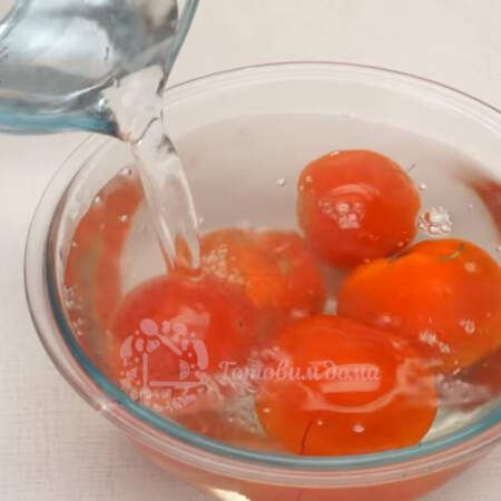 Берем полкилограмма свежих помидоров и делаем на каждом из них крестообразный надрез. Все помидоры заливаем кипятком и оставляем на 5 минут. 