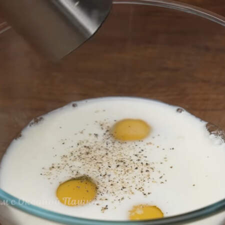 В отдельную миску разбиваем 3 яйца, сюда же наливаем 150 мл молока. Солим по вкусу и перчим.