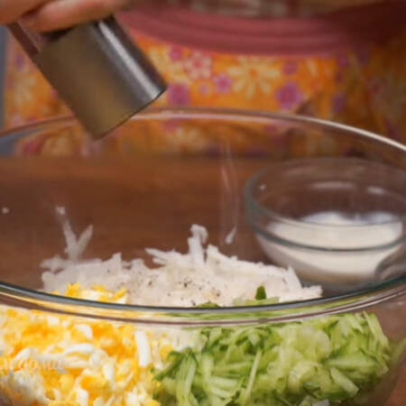 В большую миску с подготовленным дайконом добавляем тертый огурец и яйца.
Салат солим по вкусу и перчим.
