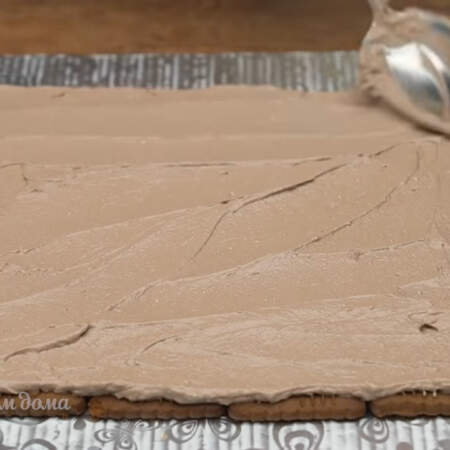  Шоколадный крем аккуратно распределяем по печенью. Печенье придерживаем второй рукой, чтоб оно оставалось на свое месте в ровных рядах.