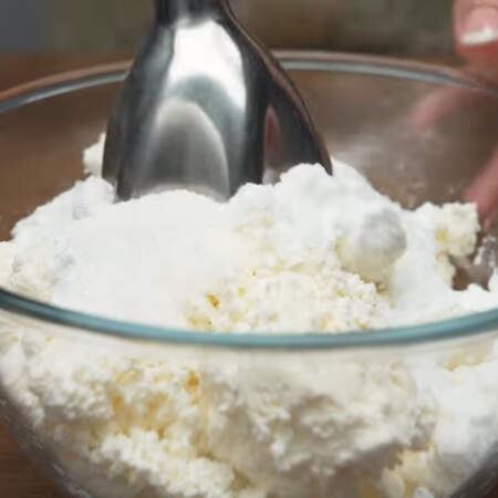 Сначала приготовим крем.
В миску кладем 500 г творога,  к нему насыпаем полстакана сахарной пудры и 10 г ванильного сахара.