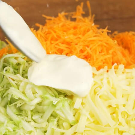В миску кладем тертые кабачки, морковь и сыр. Сюда же добавляем 1-2 ст.л. майонеза и хорошо перемешиваем. 